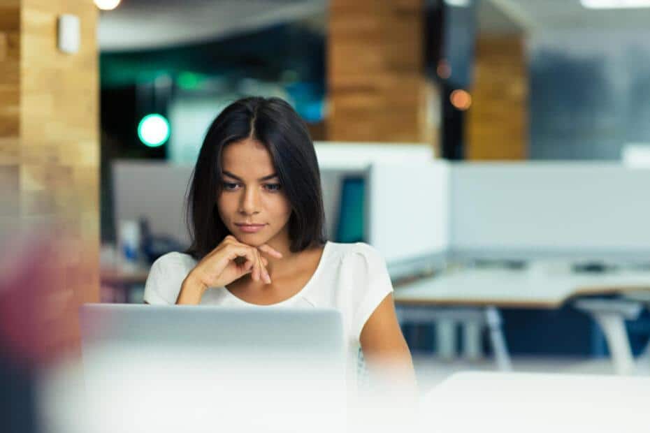 woman looking at laptop screen at work