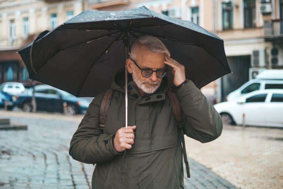man with migraine in the rain.