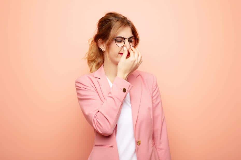 Woman holding her nose.