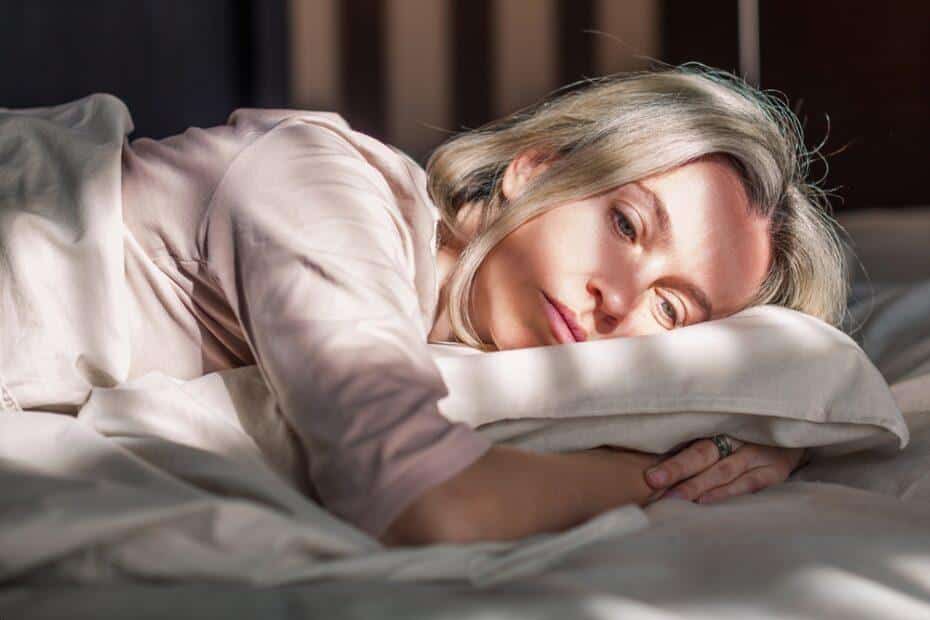 Woman laying down with migraine.