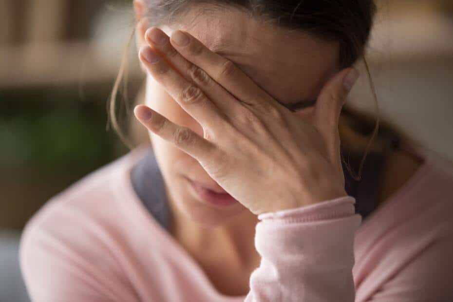 woman holding her head in pain.